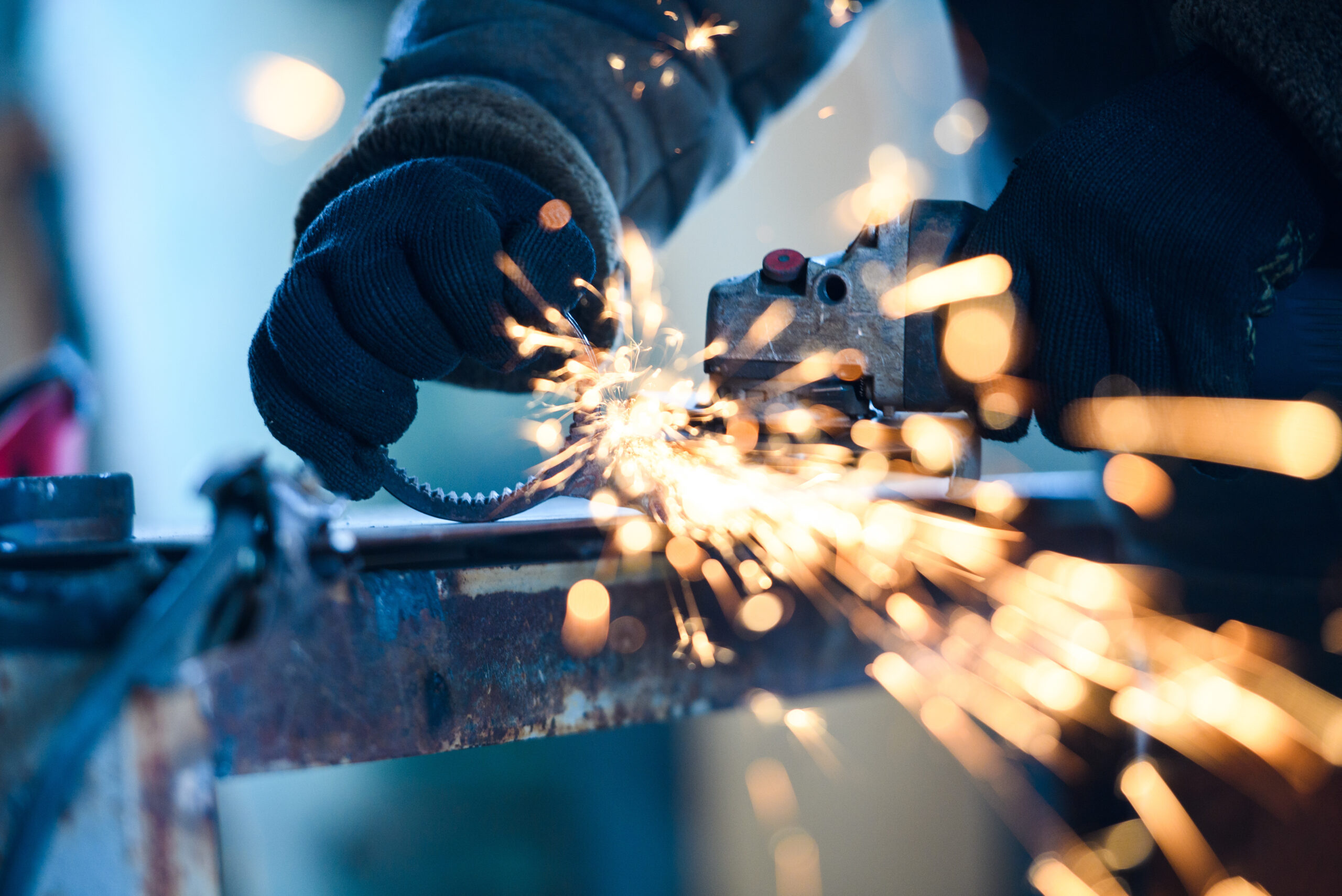 Metal grinding on steel pipe with flash of sparks close up